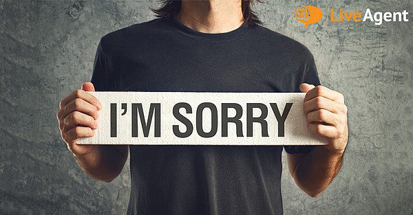 Mann holder opp 'I'm sorry'-skilt